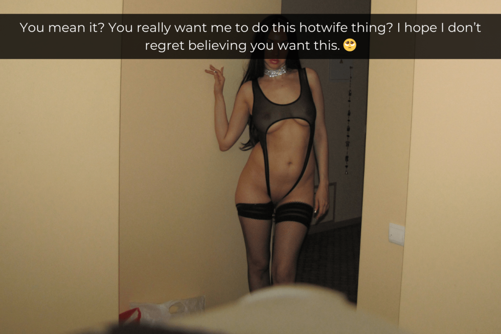 Woman standing in a doorway wearing skimpy black sheer lingerie that shows off her body