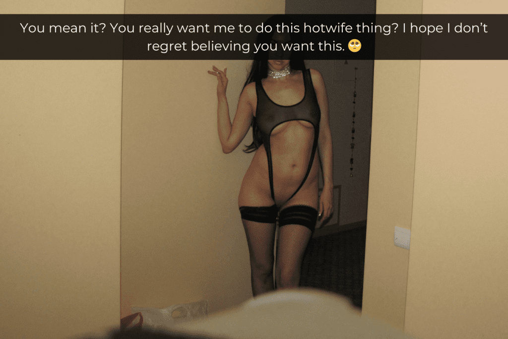 Woman standing in a doorway wearing skimpy black sheer lingerie that shows off her body