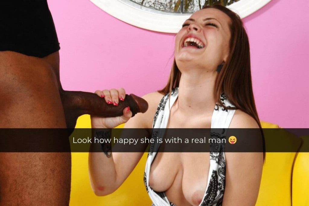 Woman on her knees, her breasts are on display and she is holding a guy's black, erect penis, with a caption over the picture that reads: "Look how happy she is with a real man"